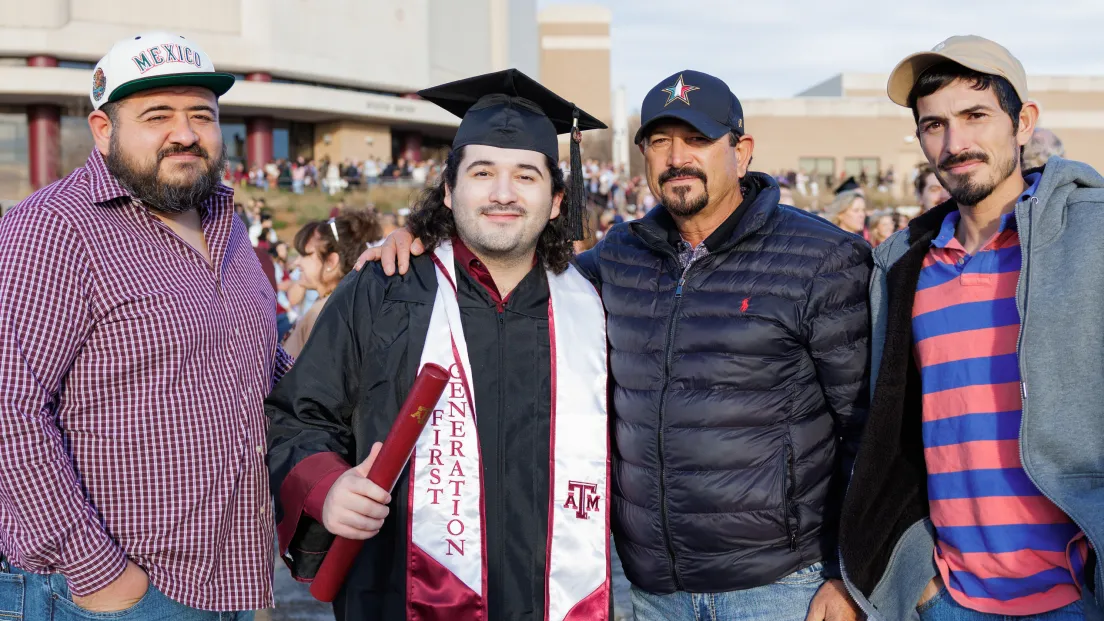 student graduating with family next to them